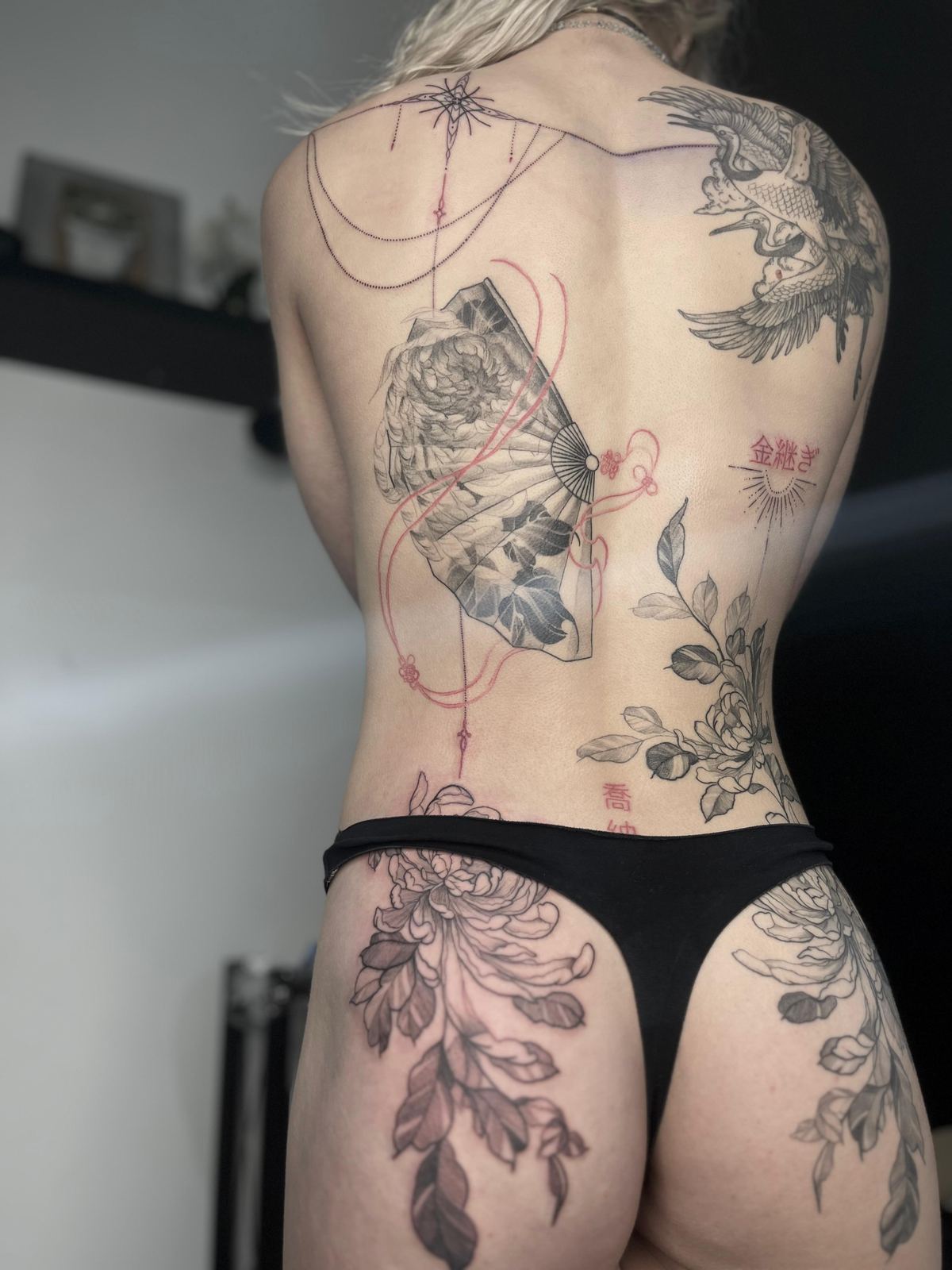 Large Japanese back piece by Tyla Storm Spence, featuring a folding fan, peonies, and a hawk with red ribbon detailing