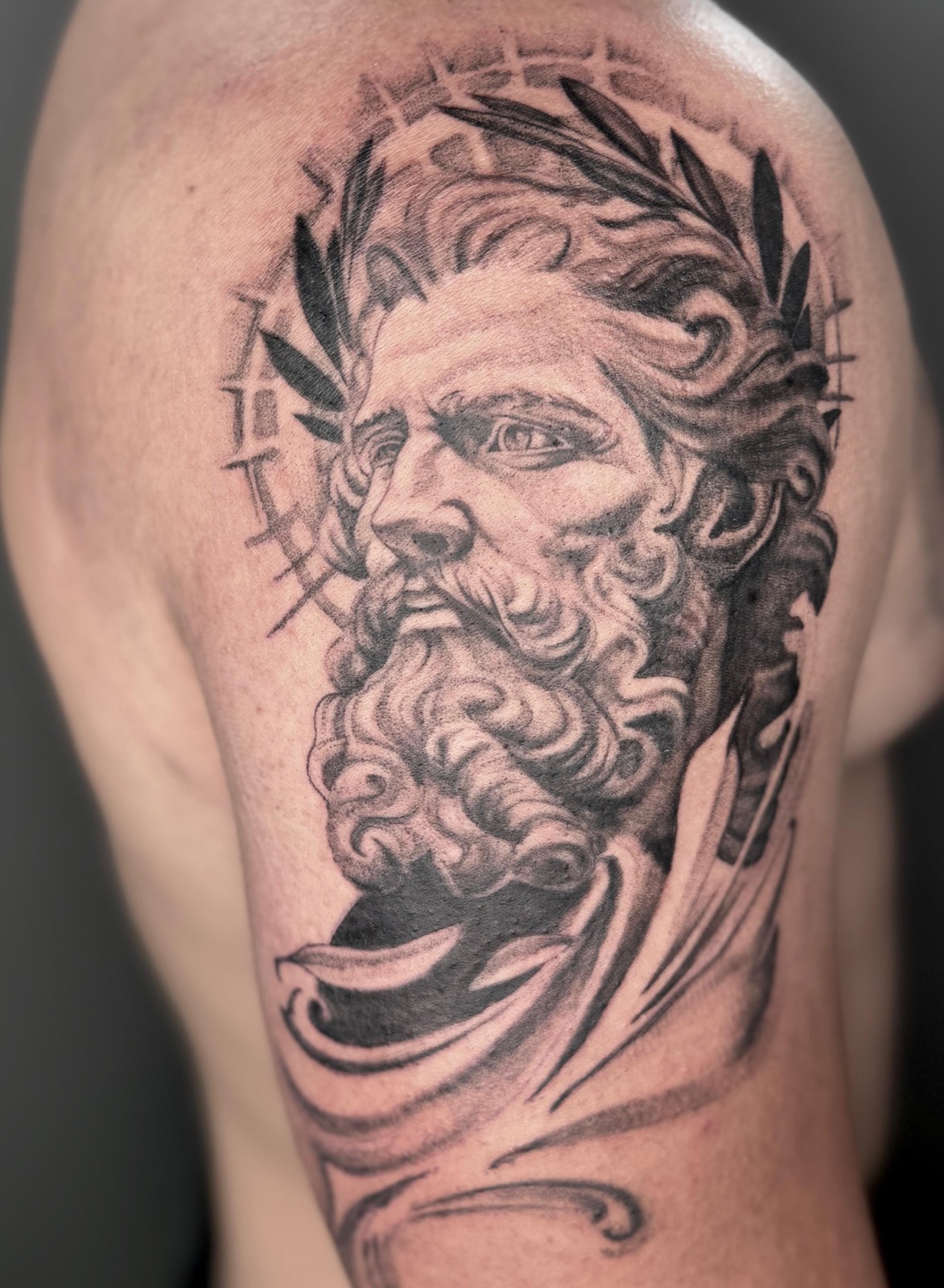Realism portrait of a Greco-Roman bearded statue tattoo on a shoulder, by Tyla Storm Spence