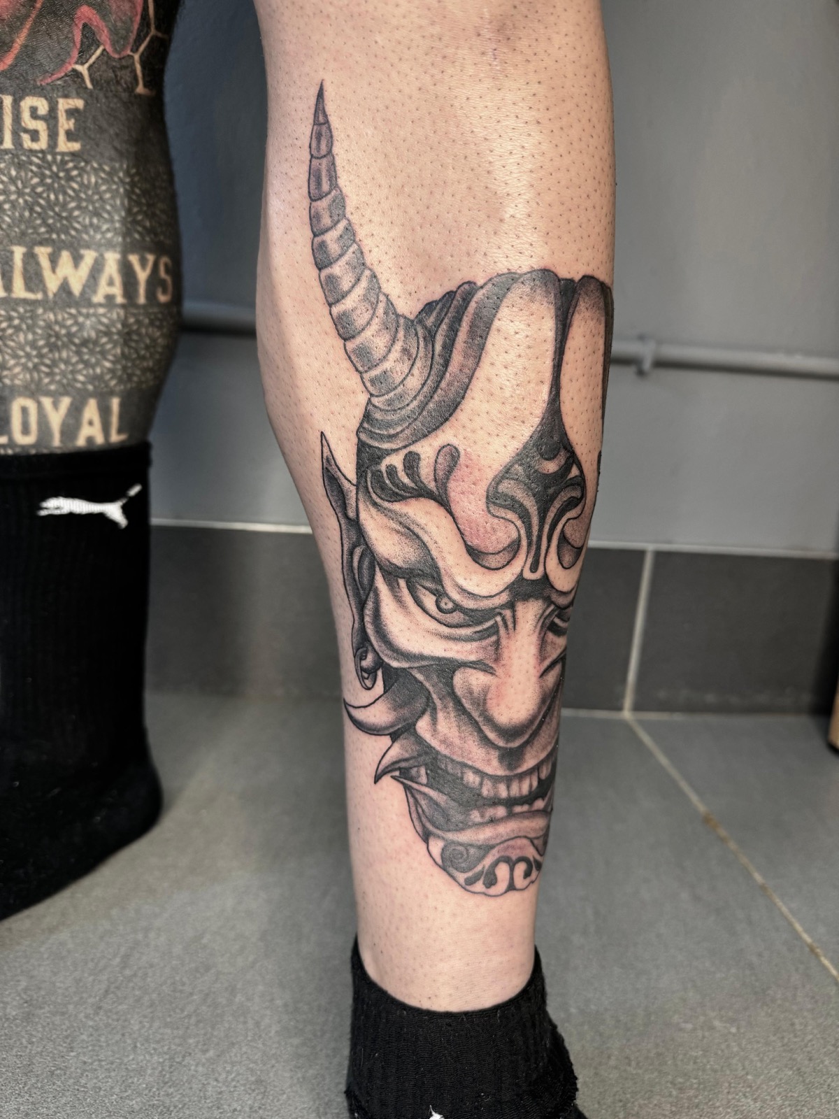 Micro-realism Hannya demon mask tattoo on a calf