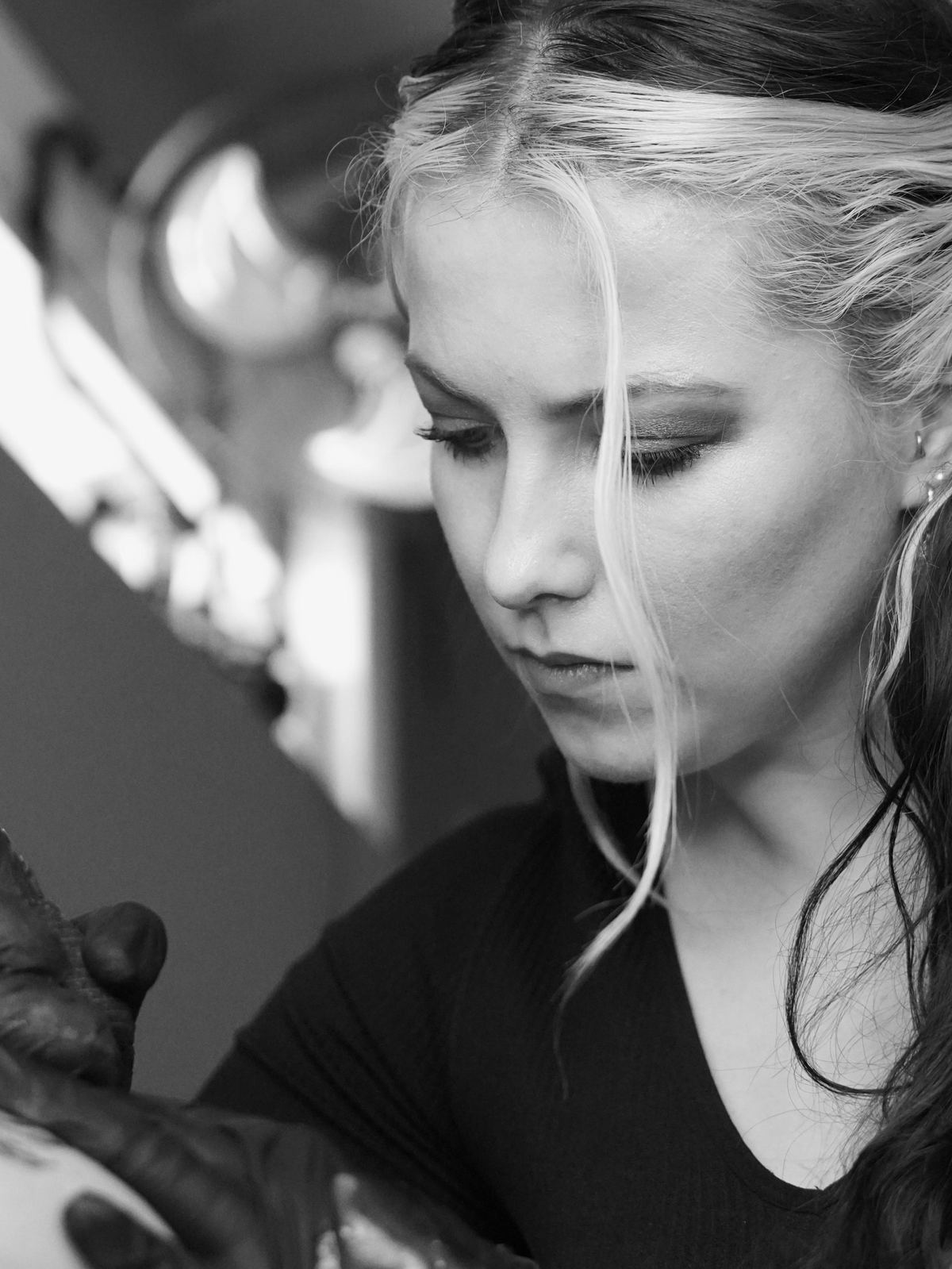 Tyla Storm Spence at work in the studio, mid-tattoo, black and white portrait